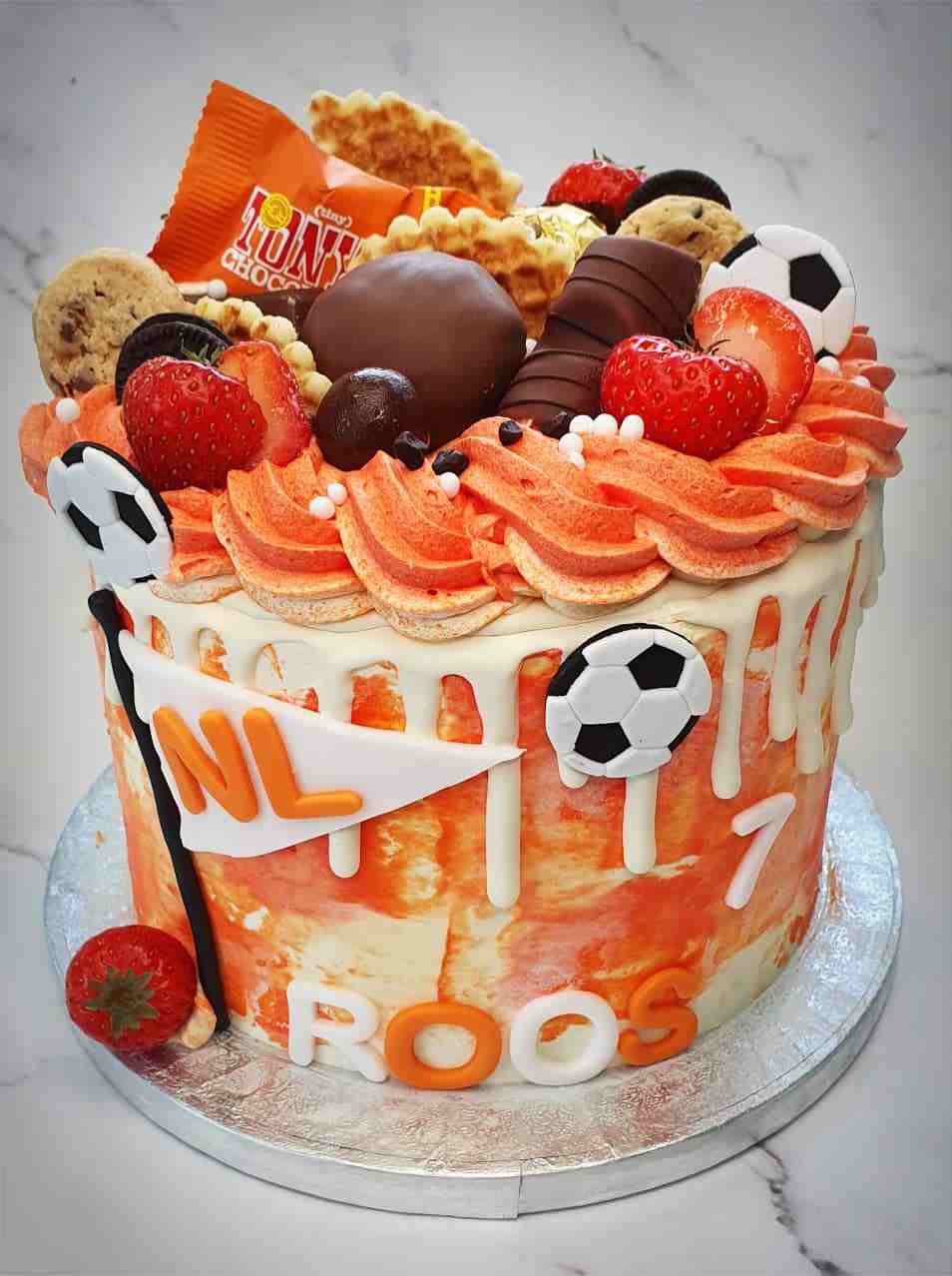 Oranje voetbaltaart voor Roos (7) met NL-vlaggetje, aardbeien, koekjes en chocolade
