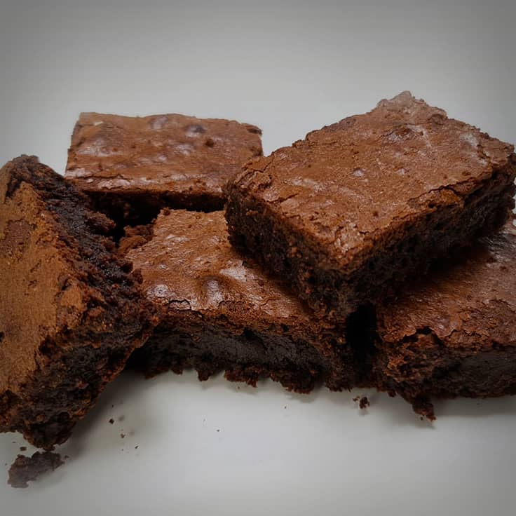 Stapel versgebakken chocoladebrownies met een glanzend krokant korstje