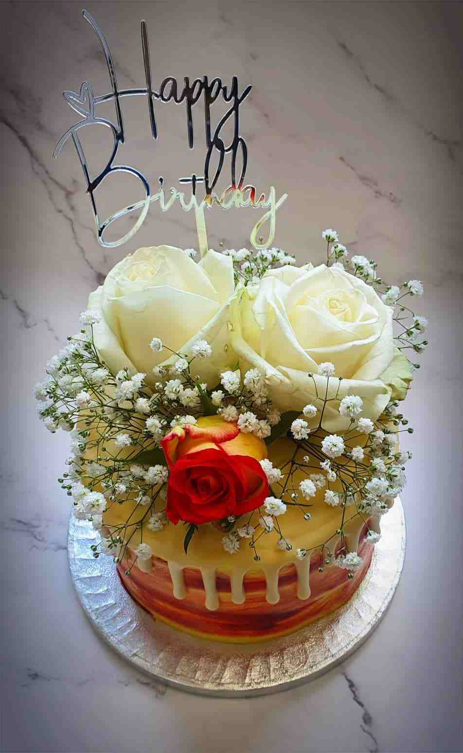 Verjaardagstaart met witte rozen, gipskruid en zilveren Happy Birthday-topper